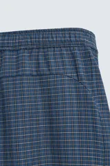 Pantalón de corte ancho (baggy fit) color azul marino con estampado de cuadros pequeños en tonos azul claro y marrón. Presenta cintura elástica ajustable con cordón interior y bolsillos frontales.