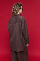 Camisa de manga larga con diseño de rayas verticales y horizontales en color marrón. Presenta un corte oversize con hombros caídos, cuello clásico y cierre frontal con botones.