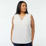 Blusa blanca sin mangas con cuello en V y borde de encaje.