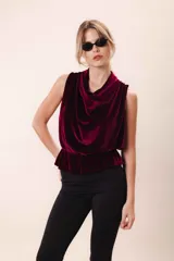 Blusa de terciopelo color borgoña, sin mangas, con escote drapeado y peplum elastizado en la cintura.