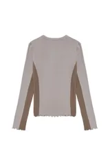 Remera de manga larga en tejido jersey, con diseño de bloques de color en tonos gris y marrón. Presenta un calce ajustado, cuello redondo y terminaciones con borde ondulado.