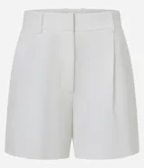 Short blanco de corte sastre, tiro alto, con pliegues frontales y trabillas en la cintura. Presenta solapas simulando bolsillos traseros.