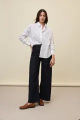 Camisa celeste de corte oversize, con mangas largas, cuello camisero y cierre frontal de botones.