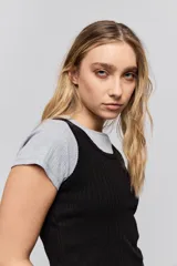 Musculosa de calce ajustado confeccionada en tejido acanalado, con escote redondo y detalle de puntilla en el escote y las sisas.