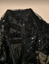 Top blanco con breteles finos, escote en V y apliques dorados. La parte inferior es de encaje con bordados de lunas, estrellas y lentejuelas doradas.