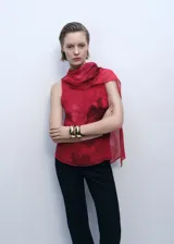 Blusa roja con estampado floral, cuello drapeado y fular, sin mangas, con forro interior y cierre de botón en la parte posterior. Prenda de gasa perteneciente a la colección de evento.