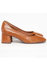 Zapato de cuero color marrón con textura de cocodrilo, de tacón cuadrado y puntera redondeada.