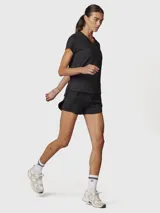Short deportivo 2 en 1 de color negro, con short interior ajustado y short exterior holgado. Presenta una cintura elástica ancha con detalle de líneas blancas y logo, además de bolsillos laterales invisibles.