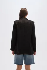 Blazer negro de corte holgado con cuello solapa y bolsillos frontales.