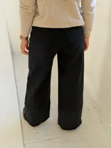 Pantalón de jean negro de corte wide leg con diseño de costura horizontal en el ruedo y terminación deshilachada. Cuenta con cierre frontal y bolsillos laterales.