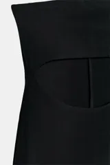 Vestido midi negro de escote recto y diseño strapless, con abertura cut out en la parte frontal y abertura en el bajo de la espalda.