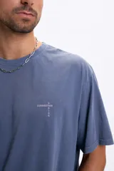 Remera de manga corta, corte oversize, color azul deslavado. Presenta un estampado vertical en la espalda con palabras en color gris claro: "CREATIVITY", "VISION", "PROGRESS", "CONNECTION", "BALANCE", "FUTURE".