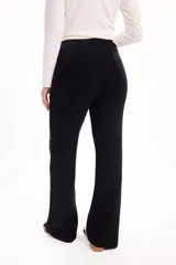 Pantalón de tejido de punto color beige, de corte recto y holgado, con cintura elástica con cordón ajustable y detalle de costuras desflecadas verticales en el frente.