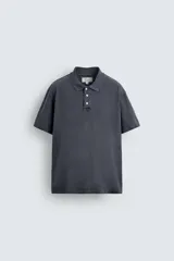 Polo de manga corta con cuello solapa y cierre frontal de tres botones. Presenta un diseño de corte relajado con acabado de efecto lavado.