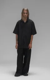 Camisa de manga corta con calce oversize, confeccionada en tejido de lyocell, con cuello clásico y cierre frontal de botones.