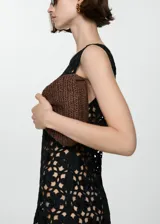 Vestido corto de crochet en color negro, con diseño de flores caladas, cuello redondo y tirantes anchos.