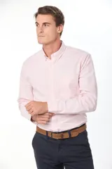 Camisa Oxford de manga larga en color rosado, con cuello abotonado (button-down) y un bolsillo aplicado en el pecho.