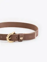 Cinturón de cuero vacuno con efecto gastado, hebilla metálica y aplique decorativo en forma de corazón.