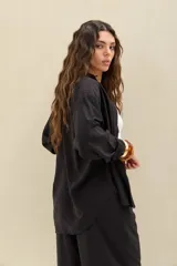 Pantalón largo negro de corte holgado, con cintura elástica fruncida y cordón ajustable delantero.
