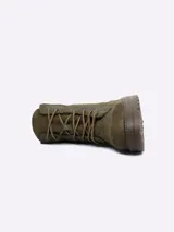 Borcego de gamuza color verde oliva, con cordones frontales y suela de goma robusta.