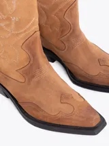 Bota estilo texana confeccionada en cuero vacuno descarne, con bordados decorativos en la caña y taco cuadrado.