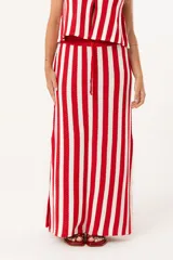 Pollera larga tejida a rayas verticales en color rojo y blanco, con pretina elástica y tajos laterales profundos que aportan movimiento.