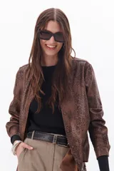 Lentes de sol negros con marco rectangular grueso y logo LMT en la patilla.