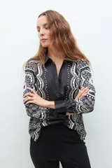 Camisa negra con estampado de arabescos en blanco y gris, de manga larga y corte clásico.