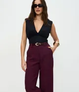 Pantalón de sastrería corte recto, color marrón, con cintura de tiro medio, trabillas largas y bolsillos traseros.