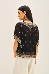 Blusa de gasa negra con escote en V, mangas amplias de largo irregular y bordados detallados con canutillos, lentejuelas y mostacillas. Incluye viso al tono con breteles regulables.