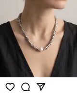 Collar de eslabones metálicos plateados con una perla central de diseño minimalista.