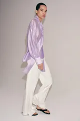 Camisa de ZARA Woman Collection confeccionada en hilatura con mezcla de lyocell, de color blanco marfil. Presenta cuello redondo, escote en V con lazadas en el mismo tejido, manga larga con puño y bajo recto.