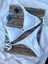 Top de bikini blanco con forma de triángulo, con copas desmontables y tirantes regulables.
