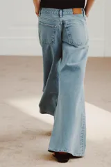 Jeans de tiro bajo y pierna muy ancha estilo wide leg, en tono celeste claro con efecto lavado. Cuenta con diseño de cinco bolsillos, trabillas para cinturón y cierre frontal con cremallera y botón metálico.