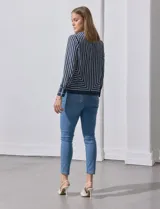 Blusa de gasa estampada con líneas verticales negras sobre fondo beige, de manga larga con puño abotonado. Espalda con abertura y botón.