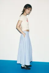 Falda midi celeste con rayas verticales finas en azul marino, de tiro alto, con pliegues en el delantero y cierre lateral con cremallera oculta.