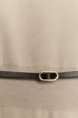 Top de punto color beige con cuello barco y mangas cortas anchas tipo murciélago. Cuenta con cintura entallada con ribete elástico y un cinturón fino de cuero sintético marrón con hebilla metálica dorada.