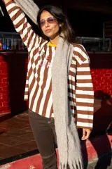 Remera de manga larga con diseño de rayas horizontales y verticales en blanco y negro, con estampado frontal multicolor.