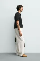 Camiseta de manga corta con cuello panadero y cierre frontal de tres botones. Presenta una textura acanalada y un corte regular fit.