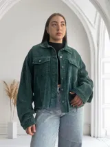 Camisa verde de pana con corte oversize, cuello clásico y cierre frontal con botones plateados.