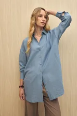 Vestido camisero negro de silueta amplia, con cuello camisero, botonadura frontal completa y mangas largas.