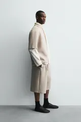 Sudadera de corte oversize confeccionada en tejido técnico de algodón con elasticidad, cuello redondo y manga corta. Presenta una tacha metálica decorativa en la parte posterior.