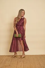 Vestido midi sin mangas de color mostaza, con escote en V cruzado y un lazo ajustable en la cintura.