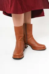 Bota de cuero color marrón con caña media, plataforma delantera de 2 cm y taco cuadrado de 7 cm.