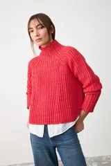 Sweater de punto acanalado en color rojo, con cuello alto y diseño de corte cropped con mangas largas.
