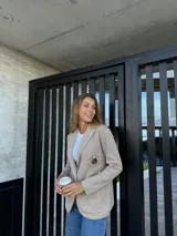 Blazer color beige de algodón con solapas y parche bordado en el pecho.