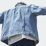 Campera de jean Wrangler en tono azul lavado, con cierre frontal de botones metálicos, cuello clásico y dos bolsillos frontales con solapa y detalle de costura en W.