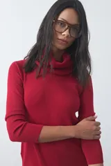 Polera de cuello alto holgado, manga larga y diseño de tejido fino con aberturas laterales en el ruedo.
