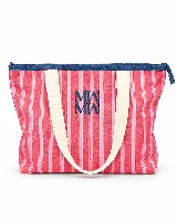 Tote bag amplia con estampado de ondas en tonos azules y verdes, asas largas de color beige, cierre superior con borde rosado y logo bordado en el centro.