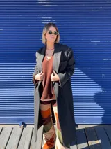 Chaqueta sastrera gris de paño con fit oversized y hombreras. Presenta detalles de hilván tipo sastre a contratono, cuello con solapa, cruce de doble abotonadura y tajo en la espalda.